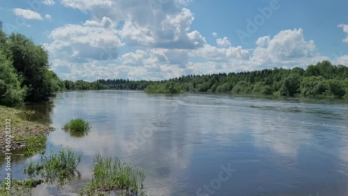 Rural landscape with river and clouds in summer.