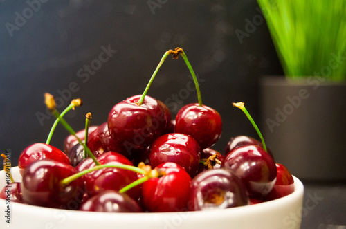 Cherries in white bowl.Cherry on grey background.Healthy eating and food concept.Selective focus. photo