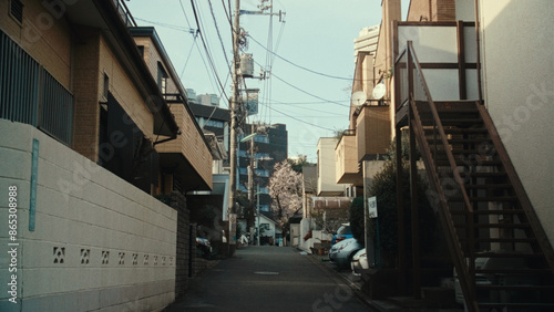 Quiet residential street in a Japanese neighborhood with power lines and buildings under a clear sky photo