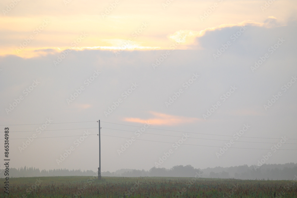 Fototapeta premium A beautiful minimalist landscape with colorful sunrise skies. Bright summer scenery of rural Latvia, Northern Europe.