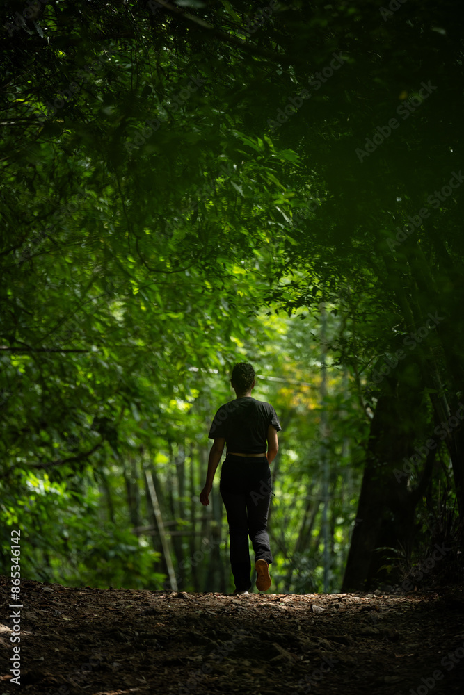 Stunning view of a girl walking in a beautiful rainforest. Khao Sok National Park, Thailand.