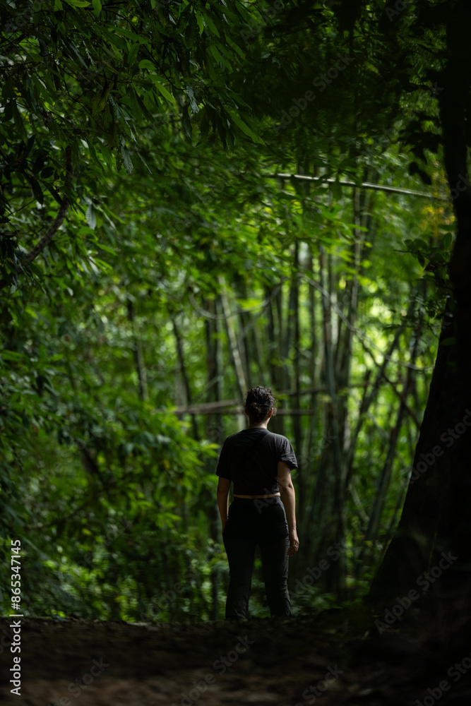 Stunning view of a girl walking in a beautiful rainforest. Khao Sok National Park, Thailand.
