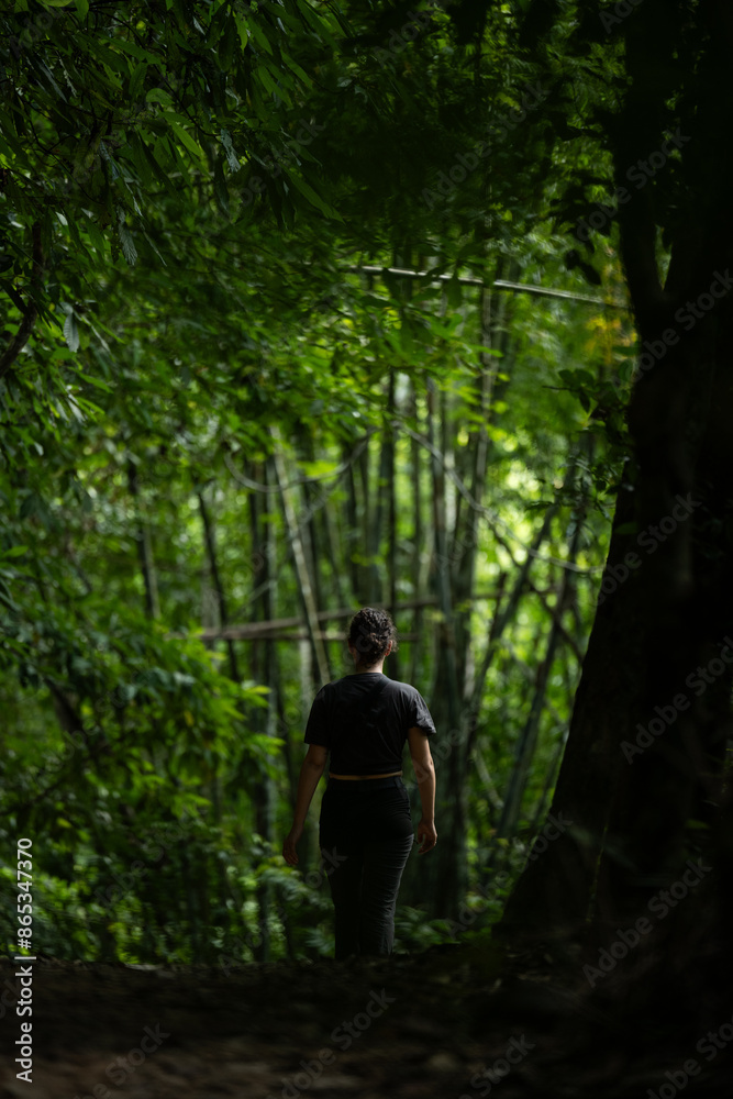 Stunning view of a girl walking in a beautiful rainforest. Khao Sok National Park, Thailand.