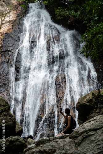 Obraz na płótnie Stunning view of a girl in front of Na Muang Waterfall, Koh Samui, Thailand. w salonie