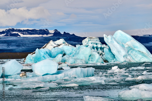 Icebergs in glacial lagoon with glacier in background, Jokulsarlon ice lagoon, Vatnajokull National Park, Iceland. September. 