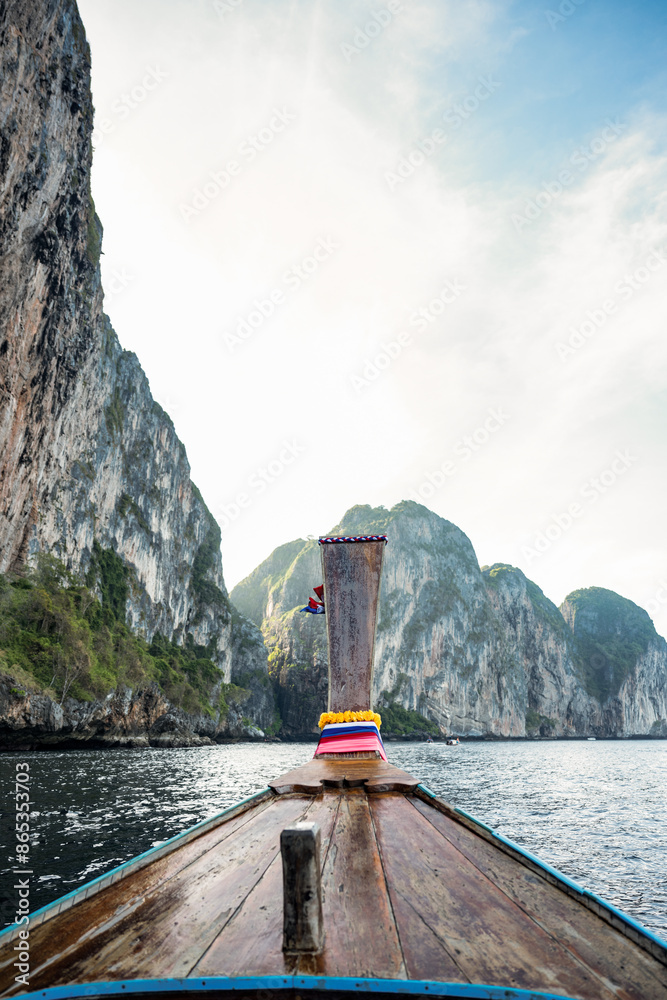 (Selective focus) Stunning view of some limestone mountains in the background and a beautiful long tail boat in the foreground. Phi Phi Islands, Thailand.