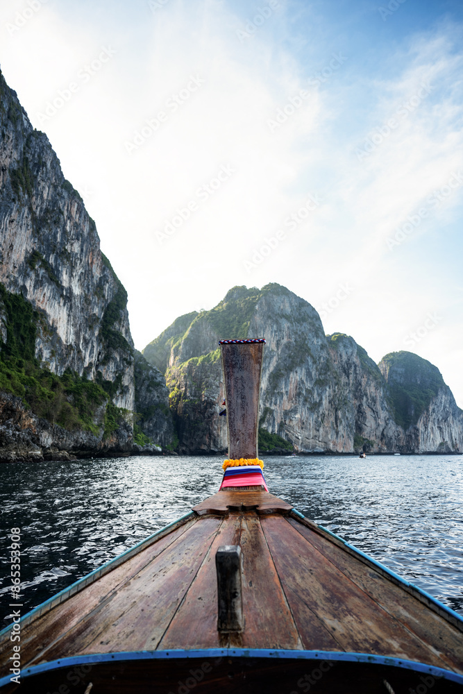 (Selective focus) Stunning view of some limestone mountains in the background and a beautiful long tail boat in the foreground. Phi Phi Islands, Thailand.