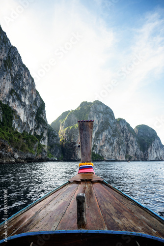 Obraz na płótnie (Selective focus) Stunning view of some limestone mountains in the background and a beautiful long tail boat in the foreground. Phi Phi Islands, Thailand. w salonie