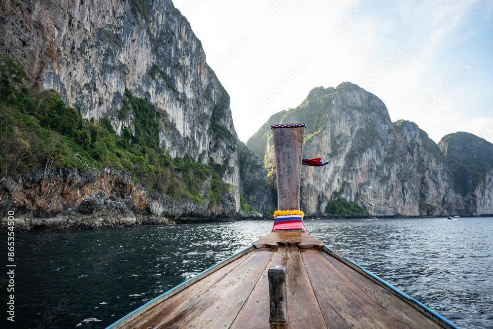 (Selective focus) Stunning view of some limestone mountains in the background and a beautiful long tail boat in the foreground. Phi Phi Islands, Thailand.