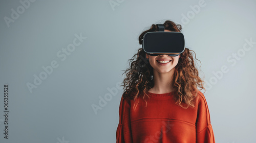 Woman with VR headset smiling on plain background 