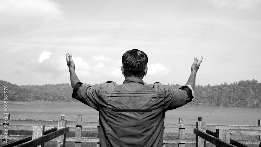 Man outstretched arms on the bridge in black and white background. Spiritual and grateful concept. Man outstretched arms on the bridge in black and white background. Spiritual and grateful concept.