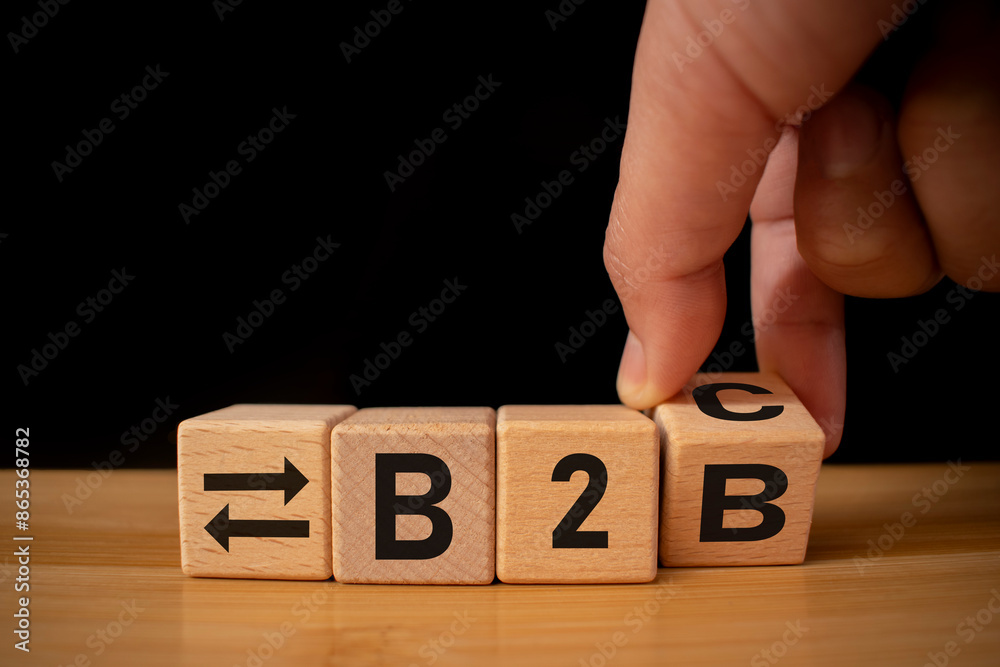 Naklejka premium Wooden cubes with with icons the letters B2B. B2B, business to business marketing symbol. Business and B2B concept. Wooden cubes table background.