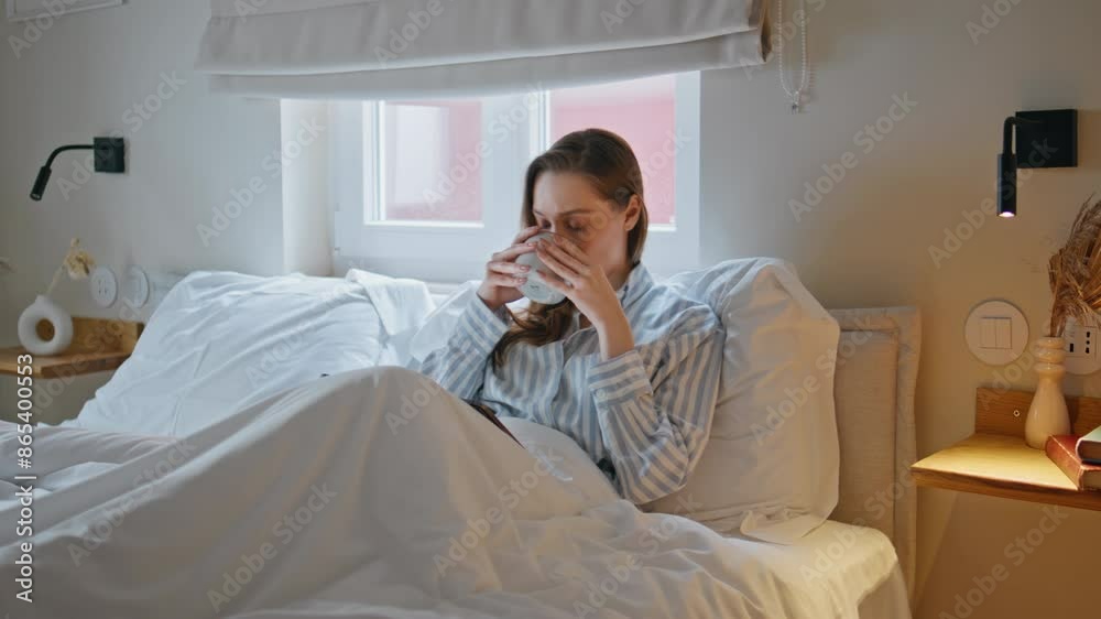 Lazy girl drinking coffee in cozy bed at morning. Calm woman reading tablet Lazy girl drinking coffee in cozy bed at morning. Calm woman reading tablet