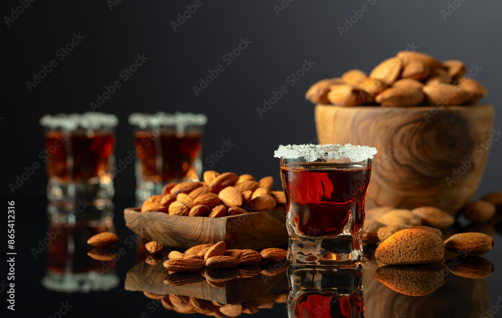 Italian liqueur Amaretto with almonds nuts on a black background. Italian liqueur Amaretto with almonds nuts on a black background.