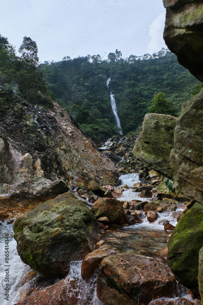 Obraz premium Cascading Waterfall Amidst Rocky Surroundings