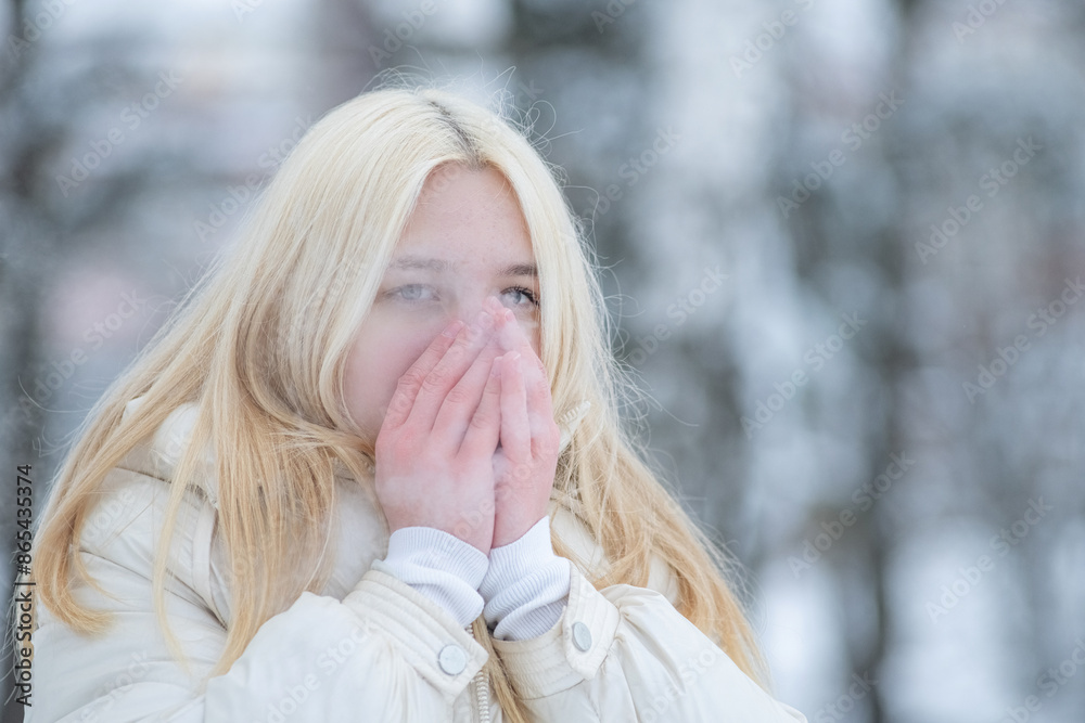 Portrait of a young beautiful blonde girl outdoors in winter in cloudy weather. Portrait of a young beautiful blonde girl outdoors in winter in cloudy weather.