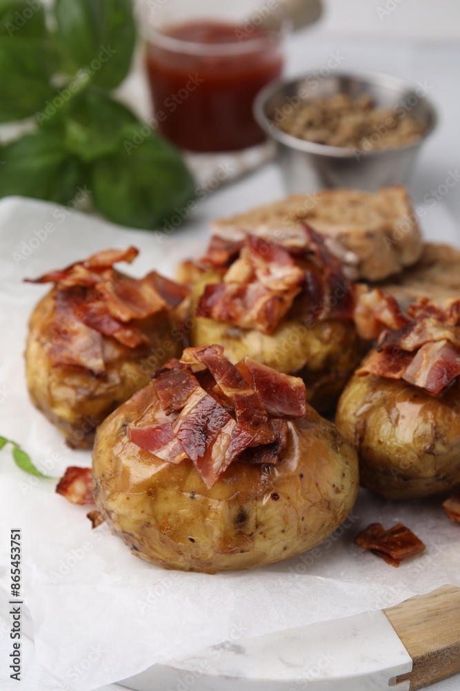 Delicious baked potatoes with bacon on table, closeup Delicious baked potatoes with bacon on table, closeup