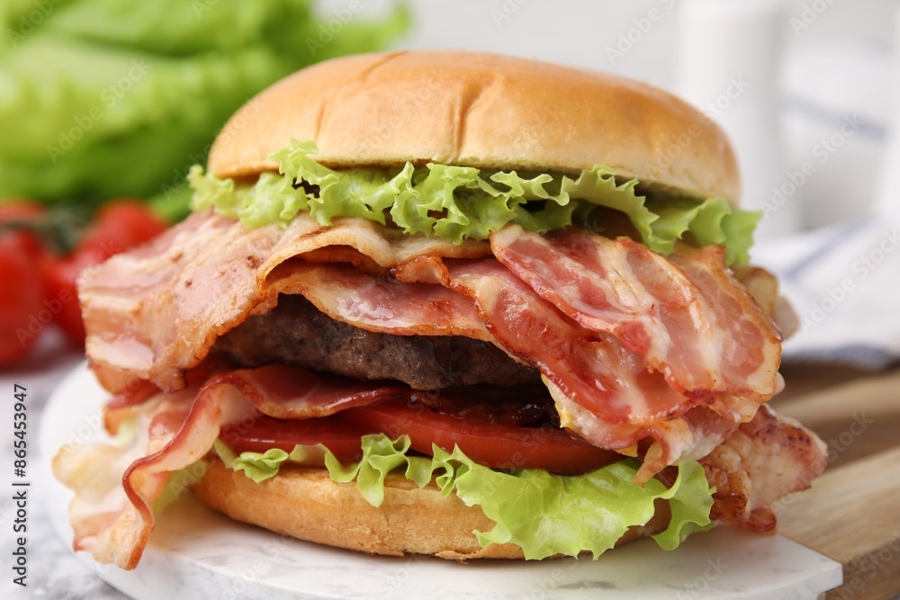 Delicious burger with bacon, patty and tomato on table Delicious burger with bacon, patty and tomato on table