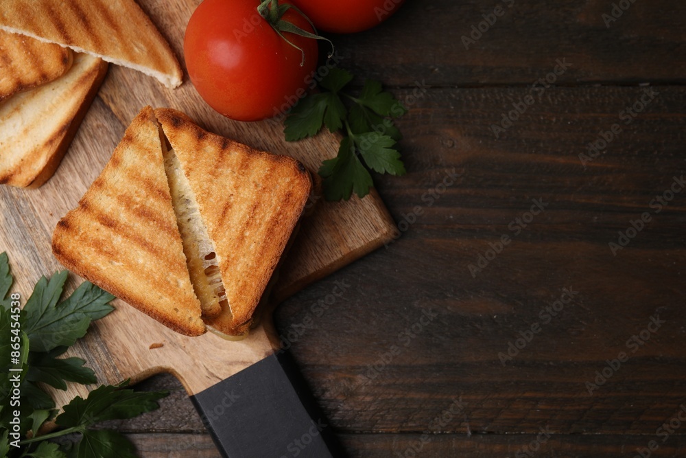 Pieces of toasted bread with melted cheese, tomatoes and parsley on wooden table, flat lay. Space for text Pieces of toasted bread with melted cheese, tomatoes and parsley on wooden table, flat lay. Space for text