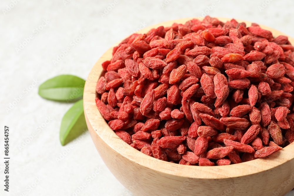 Dried goji berries in bowl on light table, closeup Dried goji berries in bowl on light table, closeup