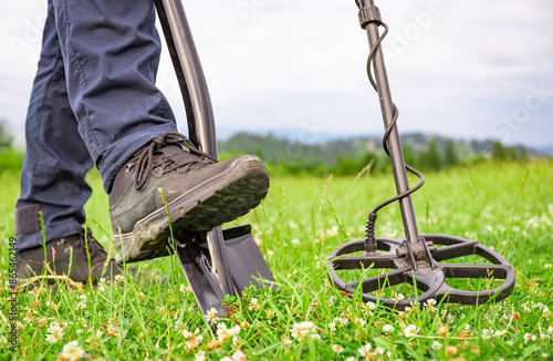 Treasure hunter with a metal detector in the mountains. photo