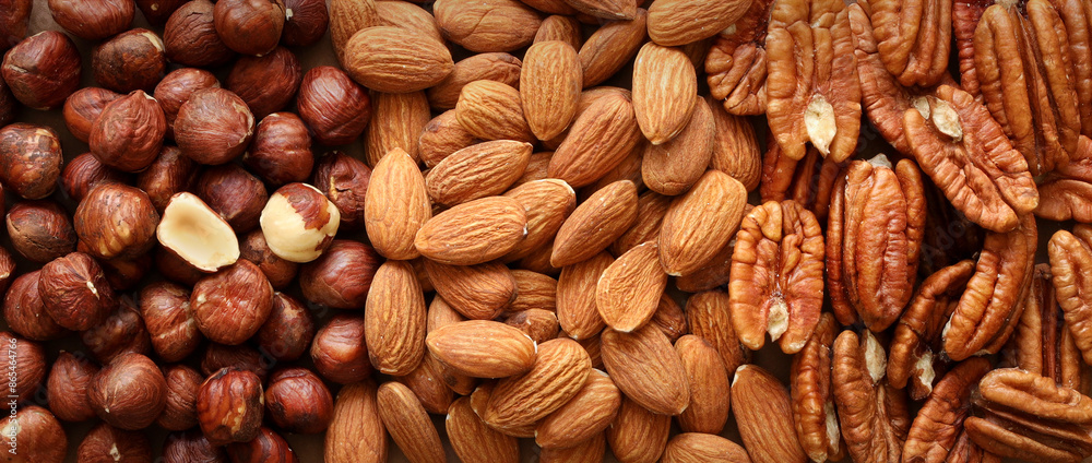 Creative layout made of hazelnut, almond, pecan nuts. Flat lay. Food concept. Nut pattern concept. Macro image. Creative layout made of hazelnut, almond, pecan nuts. Flat lay. Food concept. Nut pattern concept. Macro image.