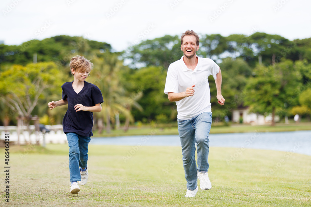 Caucasian white man and son running and relaxing at the park. Caucasian white man and son running and relaxing at the park.