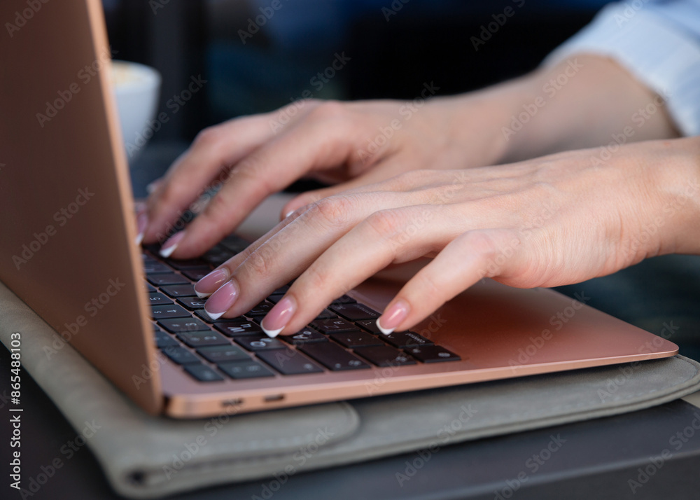 Close-up of businesswoman hands typing on laptop keyboard in cafe Close-up of businesswoman hands typing on laptop keyboard in cafe