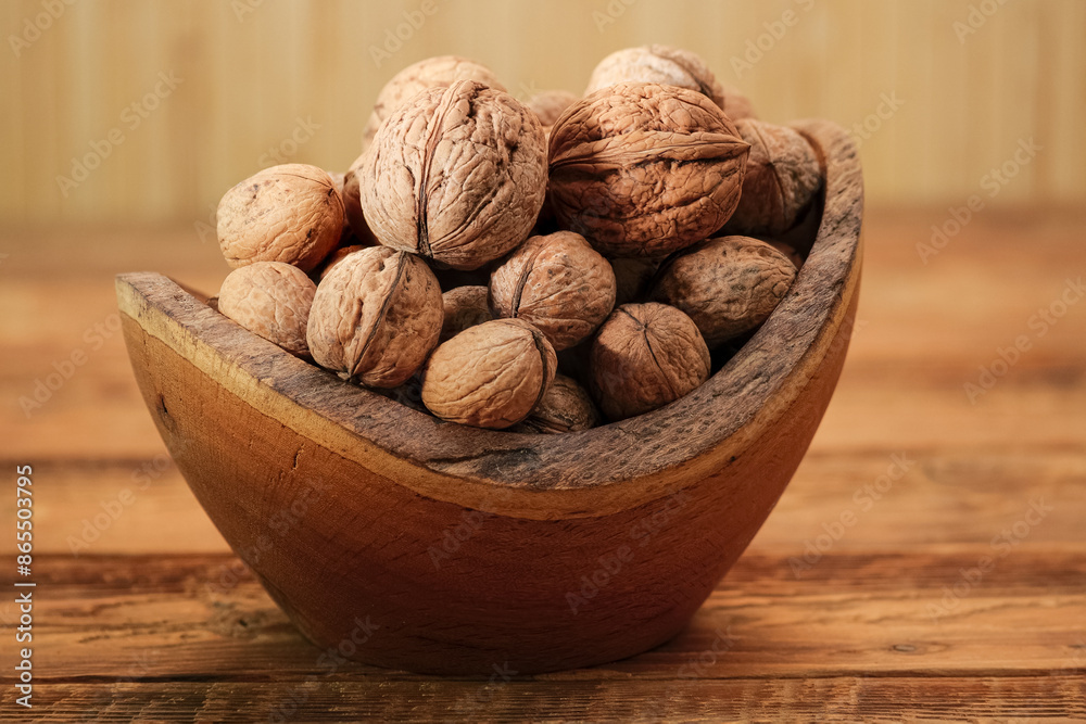 Walnuts in Wooden Bowl on a Brown Background. Whole Walnut on Rustic Table Walnuts in Wooden Bowl on a Brown Background. Whole Walnut on Rustic Table