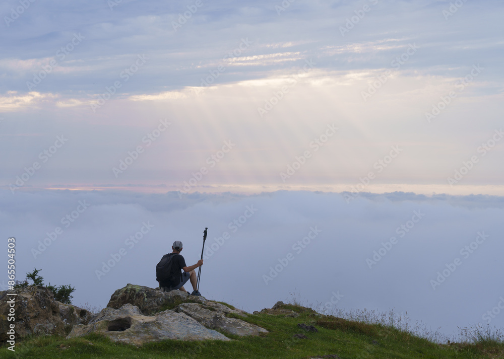 Pilgrimage to Santiago de Compostela. Pilgrim watching the sunset, north road on mount Jaizkibel, Euskadi. Pilgrimage to Santiago de Compostela. Pilgrim watching the sunset, north road on mount Jaizkibel, Euskadi.