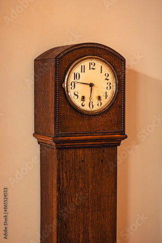 Antique grandmother or grandfather clock with detail in wood grain, lighting and shadows photo