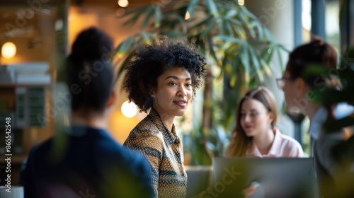 Vielfältiges Team in einem modernen Büro, das in einem hellen, freundlichen Umfeld zusammenarbeitet und dabei natürliche Interaktionen und echte Emotionen zeigt - Inklusivität und Zusammenarbeit