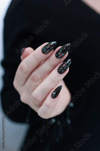 Female hands with long nails and black and red nail polish