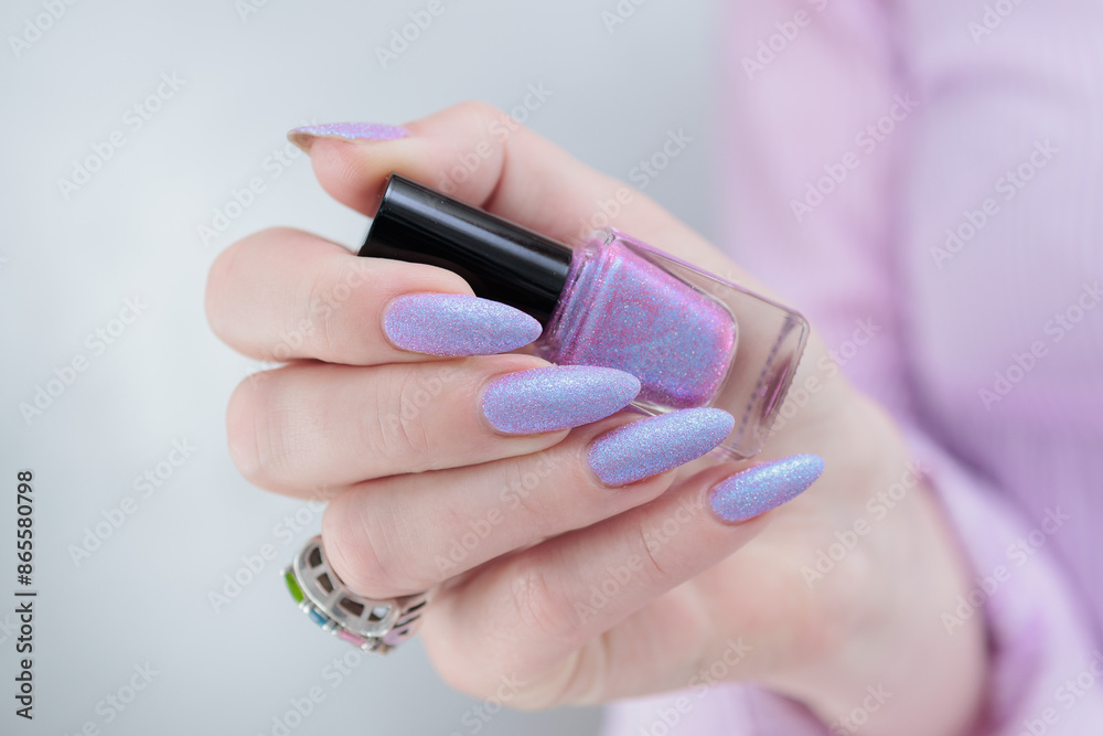 Fototapeta premium Woman hand with long nails manicure and light blue and pink nail polish