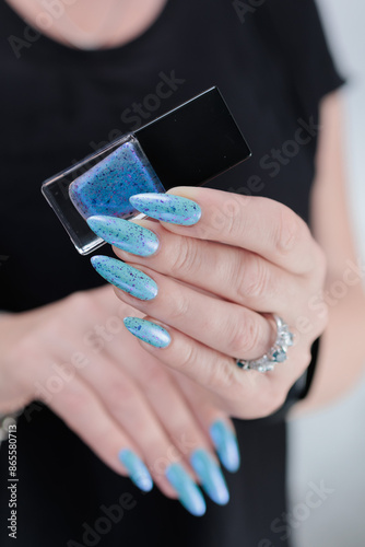 Woman's beautiful hand with long nails and light blue manicure