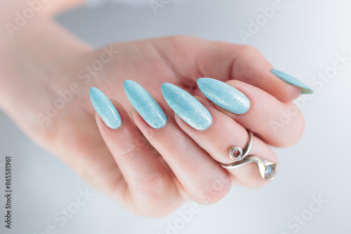 Tableau sur toile Woman's beautiful hand with long nails and light blue manicure