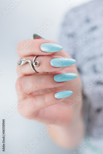 Woman's beautiful hand with long nails and light blue manicure