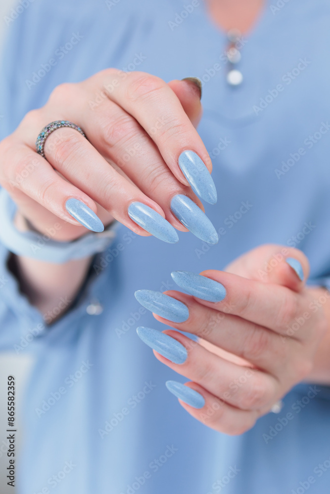 Woman's beautiful hand with long nails and light baby blue manicure Woman's beautiful hand with long nails and light baby blue manicure