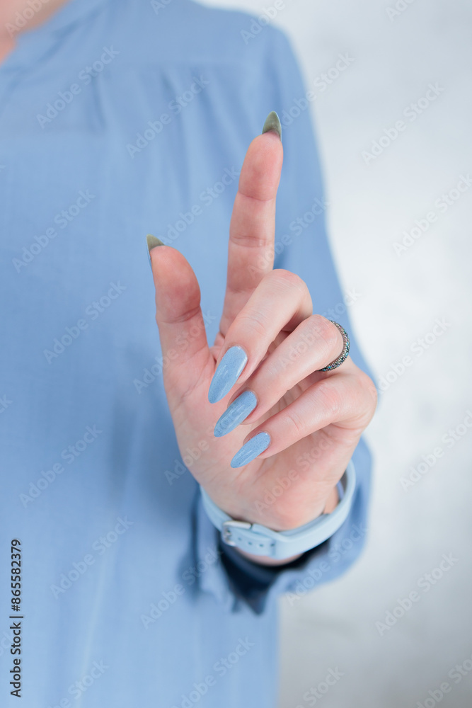 Naklejka premium Woman's beautiful hand with long nails and light baby blue manicure