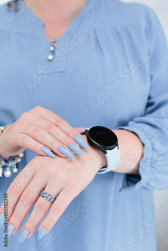 Woman's beautiful hand with long nails and light baby blue manicure