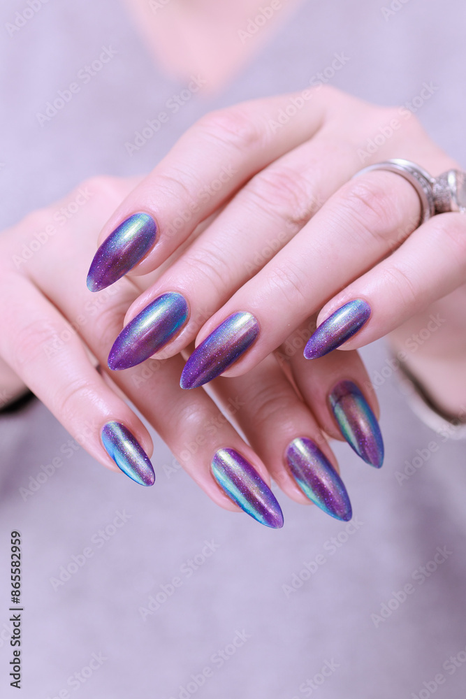 Fototapeta premium beautiful female hand with long nails, golden, purple and blue manicure 