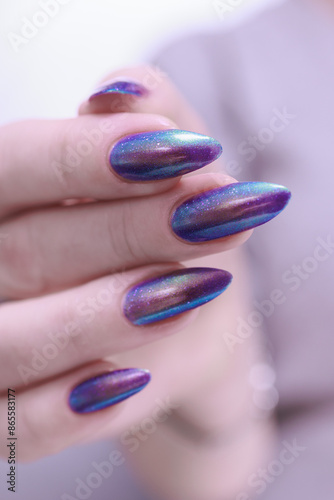 beautiful female hand with long nails, golden, purple and blue manicure	