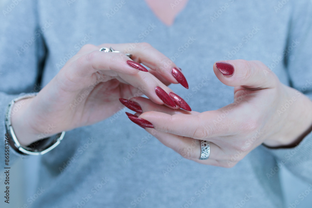Female hands with long nails and dark black red nail polish Female hands with long nails and dark black red nail polish