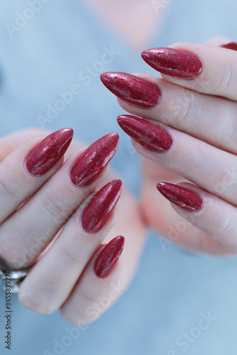 Female hand with long nails and a bright red manicure 