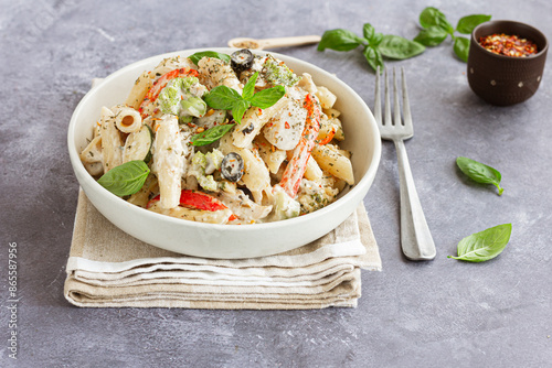 Creamy Penne Alfredo Pasta Garnished with Herbs, Chilli Flakes and Fresh Basil Leaves