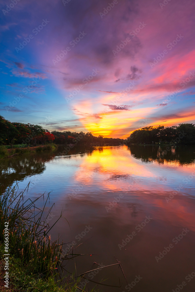 landscape lake views and the reservoir the forest summer water reflection with Twilight blue bright and orange yellow dramatic sunset sky in beach colorful nature background.