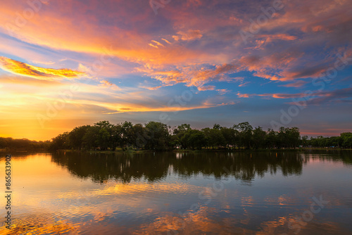 landscape lake views and the reservoir the forest summer water reflection with Twilight blue bright and orange yellow dramatic sunset sky in beach colorful nature background.