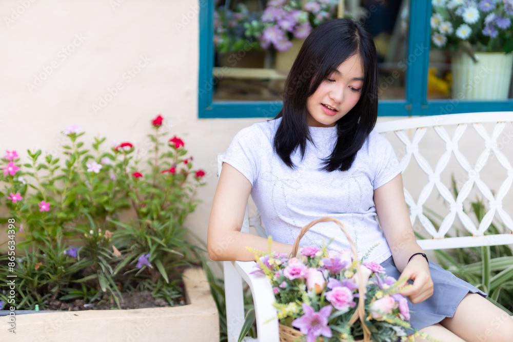 Portrait cute smiles Asian of attractive young teenage girl with a basket of flowers sit on a bench the cafe on vacation at a coffee shop in spring day Portrait cute smiles Asian of attractive young teenage girl with a basket of flowers sit on a bench the cafe on vacation at a coffee shop in spring day