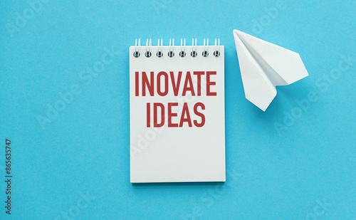 Inovate Idea slogan Note pads on blue background with notebook and paper airplane photo