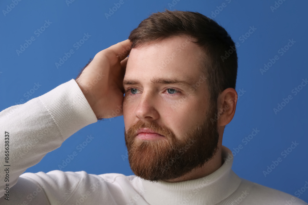 Obraz premium Handsome bearded man on blue background, closeup